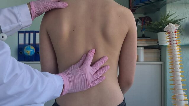 Pediatrician examining little girl with back problems. Scoliosis and postural disorders in children and adolescents