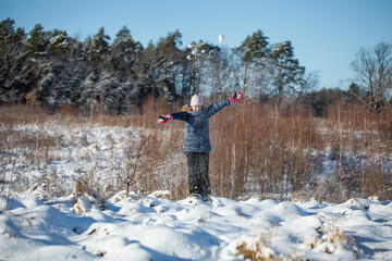 dziewczynka bawi się na śniegu zimą w ferie zimowe - obrazy, fototapety, plakaty
