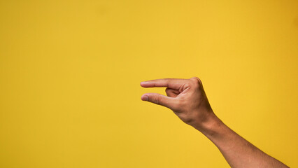 Men's hands with small gestures on a yellow background
