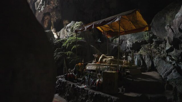 Sacred cave of Tham Phu Kham Vang Vieng, Laos - a stalactite and a stalagmite in the karst mountain with buddha temple inside