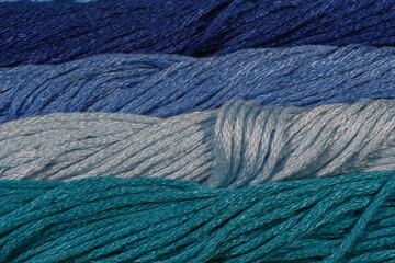 Niebieskie tło struktura skręconych nici sznurków, poziome pasy w różnych pastelowych odcieniach 