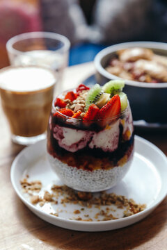 Healthy breakfast with chia strawberry pudding, oatmeal bowl with banana, peanut butter, blackberries, raspberries, nuts, seeds and goji berries