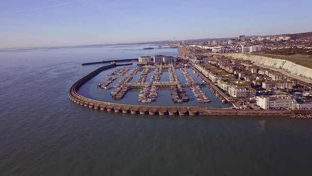 Approaching Brighton Marina in East Sussex, Southern England, with Brighton beach in view, a popular holiday destination, aerial video.
