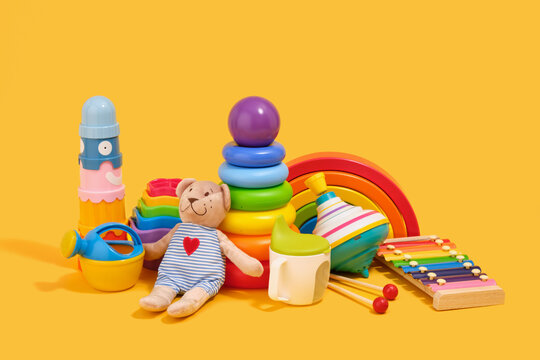 Colorful bright toys for babies on a yellow background. Educational toys. Concept of the childhood.