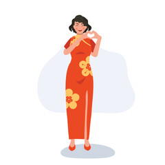 Festive Chinese New Year concept. Smiling Woman in Red Dress with Symbolic heart Hand Gesture