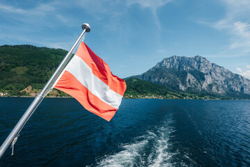 austrian flag on the stern of a ship on lake traunsee in austria - 713921163