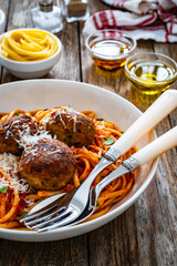 Spaghetti meatballs in tomato sauce on wooden table
