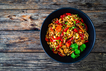 Asian style stir fried vegetables and noodles on wooden table
