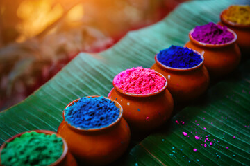 Various colors of Holi in pots on a large palm leaf with copy space against the background of...