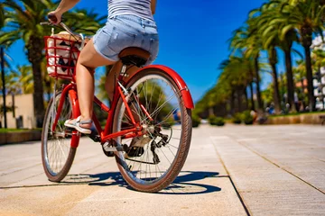 Foto auf Glas Woman riding bicycle on seaside boulevard Costa Dorada Spain  © Jacek Chabraszewski
