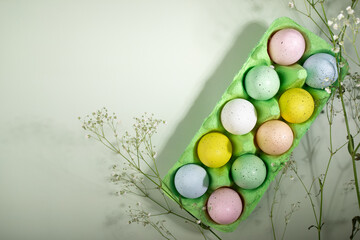 Festive DIY for Easter, eggs in a box, spring flowers, green backdrop, holiday decor