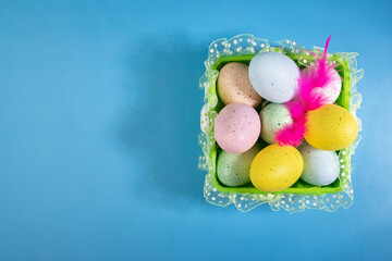 Happy Easter day, festive eggs, spring feather, blue background, DIY decoration