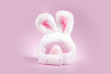 Easter egg and bunny ears on a pink background, spring celebration, decorated egg, festive tradition
