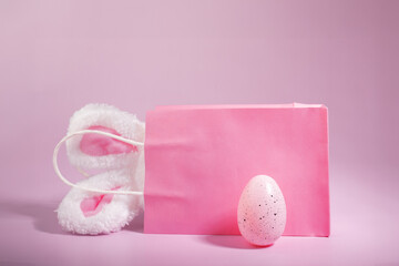 Spring shopping delight, bunny ears bag and Easter egg, pink backdrop, rabbit-themed discounts