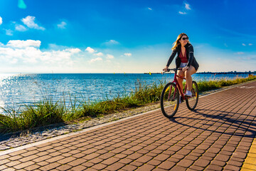 Mid adult woman riding bicycle at seaside
