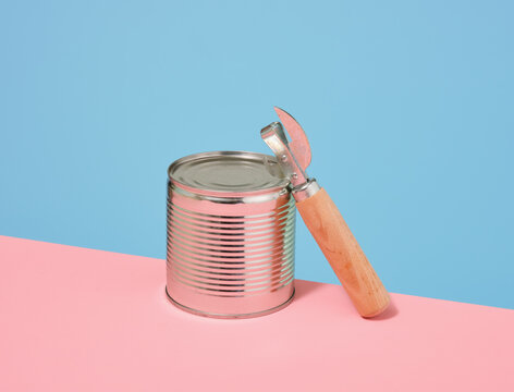 Canned with different types of fish and can opener with wooden handle. Concept of food stocks and cooking.