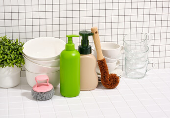 Set of clean washed dishes and cups. Dishwashing gel dispensers and brushes, sponges.