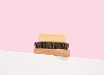 Natural soap and a wooden brush with black bristles. Ecological cleaning.