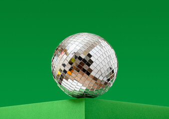 A shining mirror disco ball and party atmosphere, dancing and fun.