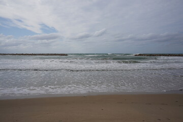 Strong currents and waves in the sea. Waves successfully crash into the stone breakwater.