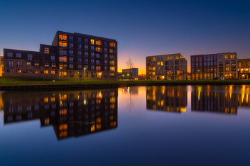 Amsterdam, Netherlands. A cityscape during sunset. A apartment building near the water in the bay. Architecture of the Netherlands. Travel photography.