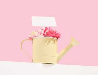 A yellow watering can with flowers. Ecology concept and copy space for text.