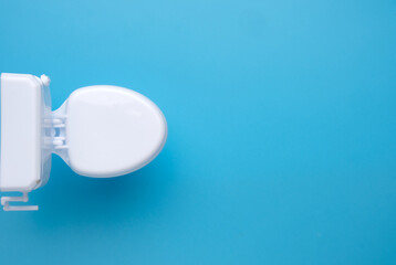 Selective focus toilet bowl on blue background.