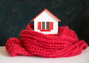 house in winter - heating system concept and cold snowy weather with model of a house wearing a knitted cap. High quality photo