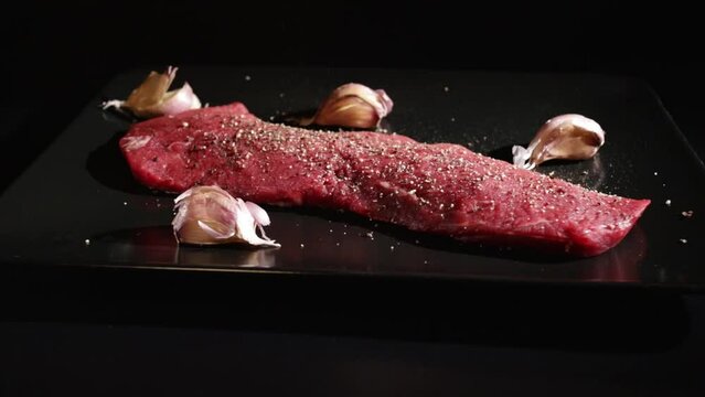 raw vegas beef steak is seasoned by the chef with fresh ground pepper