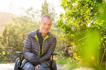 Portrait of cheerful disabled man using wheelchair in a park