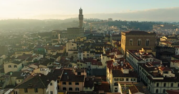 Twilight Elegance: A Cinematic Aerial Exploration of Florence's Torre della Castagna Tower, Immersed in the Romantic Atmosphere of Old-European Streets, as the Sun Sets and City Lights Begin to Glow. 