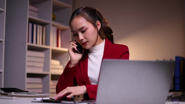 I dont want to hear excuses, just get it done. Serious Asian businesswoman talking on a mobile phone during a late night at work.