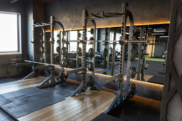 Dark gym with barbells, weights and different exercise tools, perfect for intense workouts and...