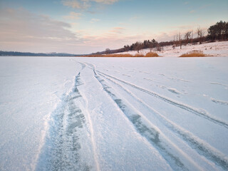 Obraz premium Calm winter scene on the frozen lake covered with snow