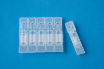 Single use artificial tear lubricant eye drops containers, tubes, isolated on blue background....