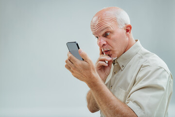 Thoughtful elder reflects on smartphone's intricate message