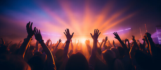 Energetic Crowd at a live concert with hands raised and colorful vibrant stage lights, music festival excitement concept