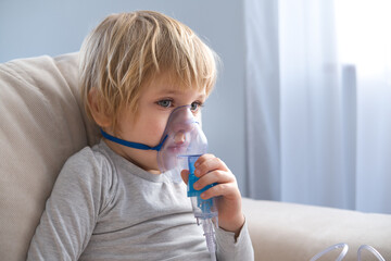 little boy using steam inhaler nebulizer. health medical care.