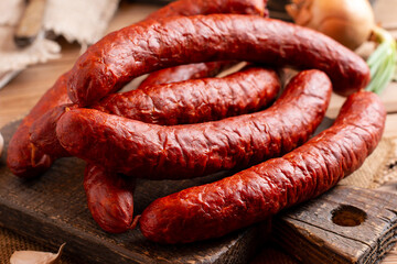 Sausage with spices on a wooden table. Dry-cured sausage with thyme, onion, garlic and pepper.