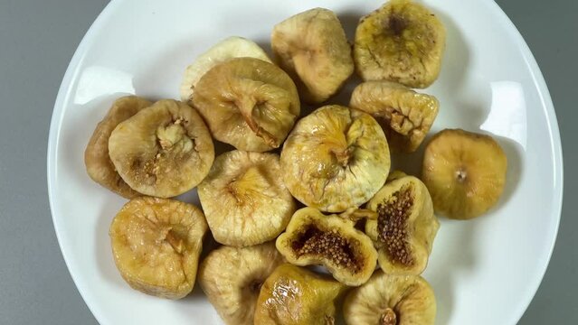 Dried figs on white dish, top view on gray background