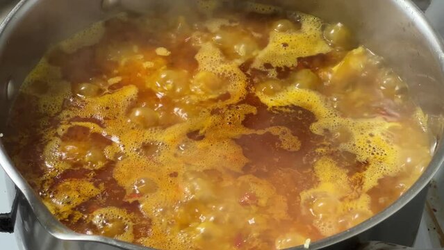 Pilaf during preparation in stainless steel pot on stove top