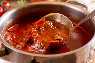 Saucepan with goulash meat, a soup or stew of meat and vegetables seasoned with paprika and spices....