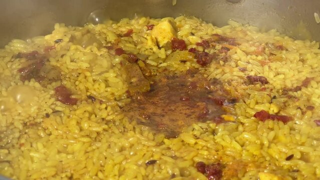 Pilaf during preparation in stainless steel pot on stove top