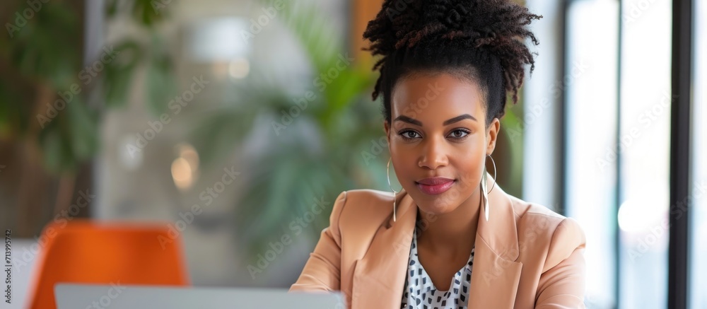 Poster Stylish African American businesswoman doing an office interview, with laptop and copy space.