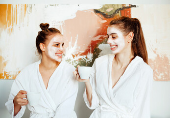 Happy girls in bathrobes with masks