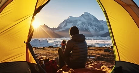 Foto op Aluminium View from inside a tent of hiker drink hot tea and looking to the mountains valley with ice glacier landscape at sunset during trekking © Godam
