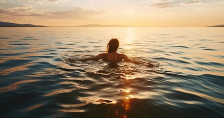 A Serene Scene of a Woman Floating Gracefully on the Sea at Sunset