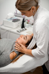 Obraz premium Cosmetologist performs a hand massage in the neck area of a client