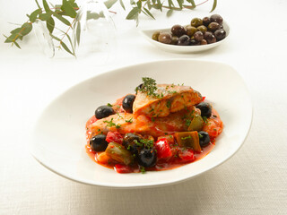 Lubina estofada sobre verduras y aceitunas negras. Braised sea bass over vegetables and black olives.