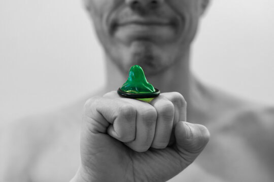 Grünes Kondom auf einer Faust